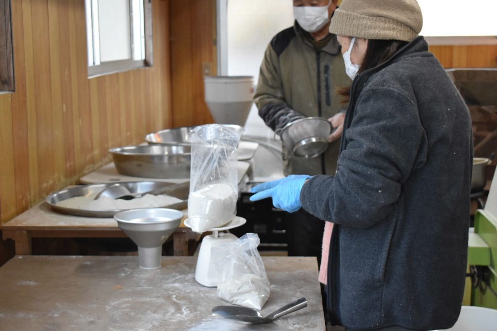 製粉した蕎麦粉を計量して袋詰めする。